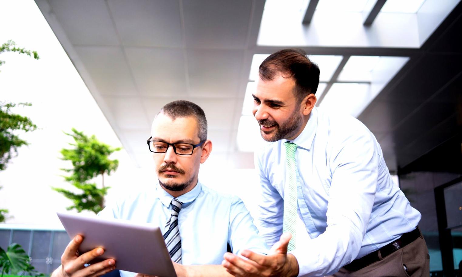 Students engaged in interactive financial planning workshop with tablets and discussion materials